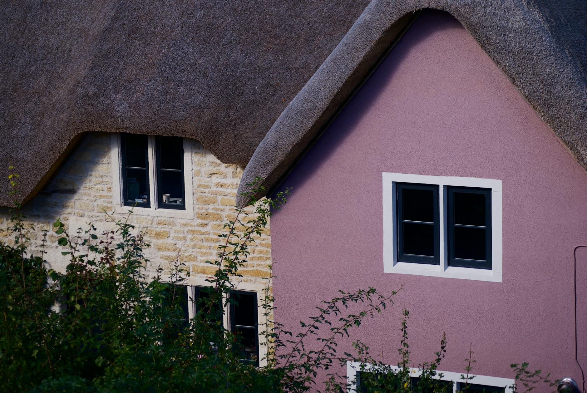 Vibrant view of thatched roof cottages in Farleigh Hungerford, England.